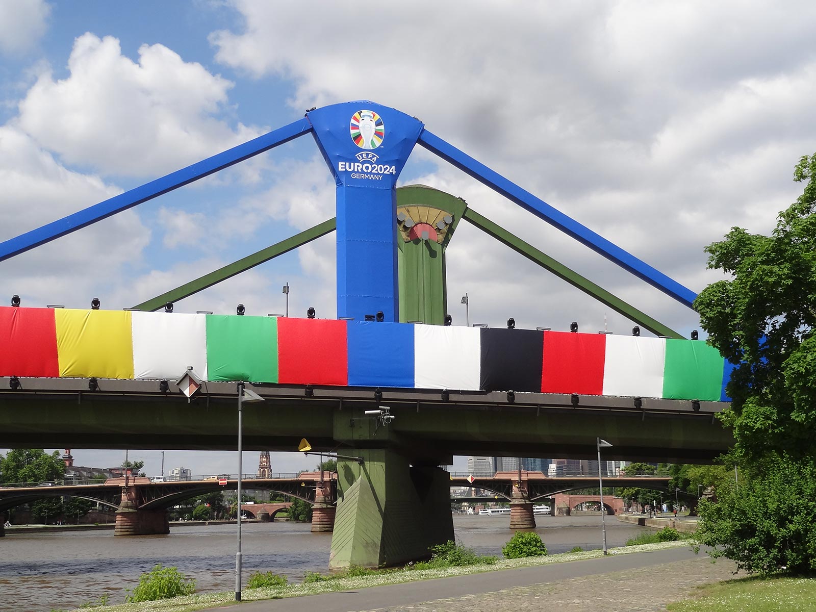 Fußball-Europameisterschaft 2024 in Frankfurt - Flößerbrücke verhüllt mit Farben von teilnehmenden Ländern