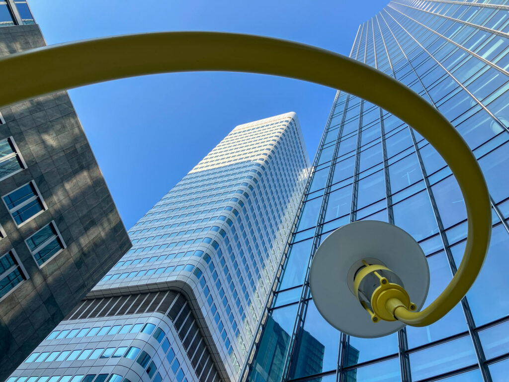 Kurvenreich gebogene gelbe Straßenlaternen von Jeppe Hein am Skyper Tower in Frankfurt